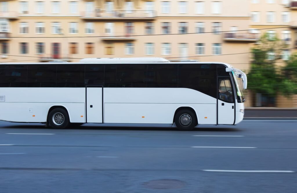 A white tourist bus for families drives along a city street.