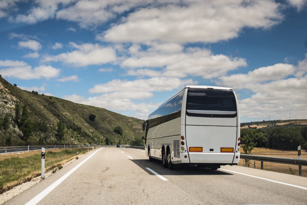 A white coach, or long haul bus for tourists drives through the open roads near New York.