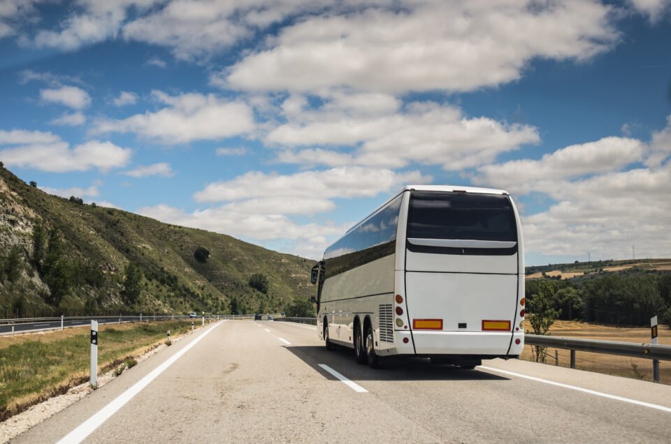 A white coach, or long haul bus for tourists drives through the open roads near New York.